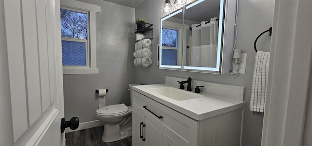 bathroom featuring toilet, hardwood / wood-style flooring, and vanity