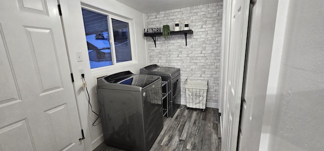 washroom featuring brick wall, independent washer and dryer, and dark hardwood / wood-style flooring