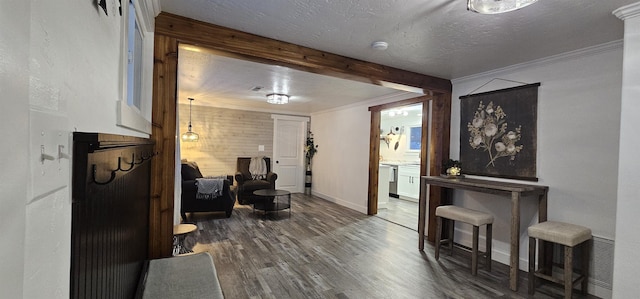 sitting room with hardwood / wood-style flooring, a textured ceiling, and ornamental molding