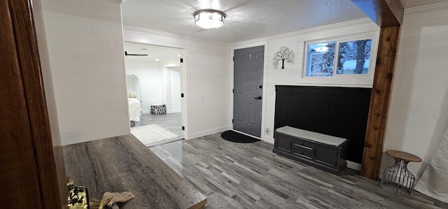 entryway featuring a textured ceiling, ornamental molding, hardwood / wood-style floors, and a barn door