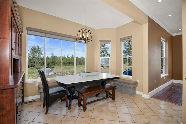 dining space with ornamental molding, light tile patterned flooring, a chandelier, and a healthy amount of sunlight