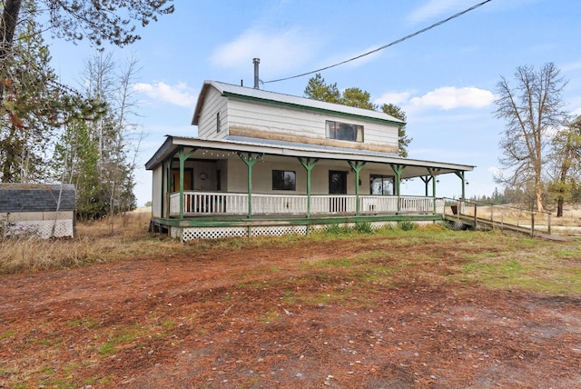 farmhouse-style home featuring covered porch and a shed