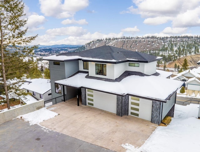 view of front of home featuring a mountain view, concrete driveway, and a garage