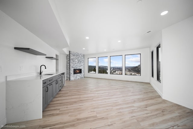 5022 S Lincoln Way, Spokane, WA 99224 - unfurnished living room featuring a sink, a fireplace, light wood-style floors, and recessed lighting