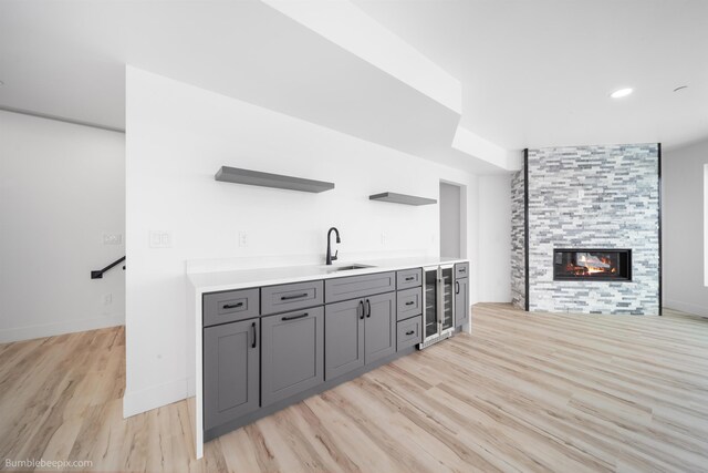 5022 S Lincoln Way, Spokane, WA 99224 - bar with wine cooler, a sink, light wood-style floors, a tiled fireplace, and baseboards