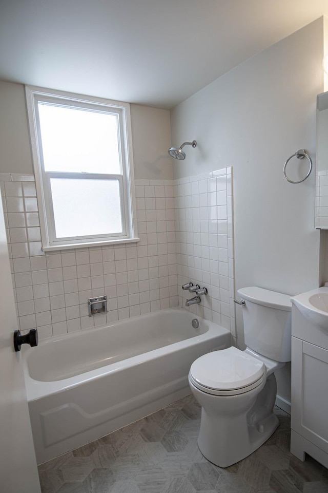 full bathroom featuring vanity, tiled shower / bath, toilet, and tile patterned floors