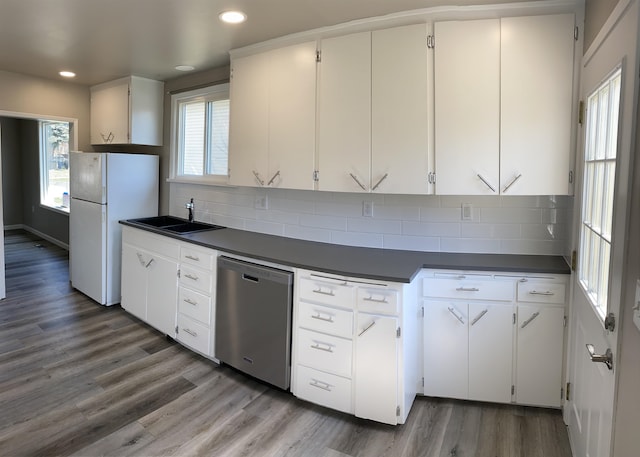 kitchen featuring white cabinetry, white refrigerator, sink, stainless steel dishwasher, and hardwood / wood-style floors