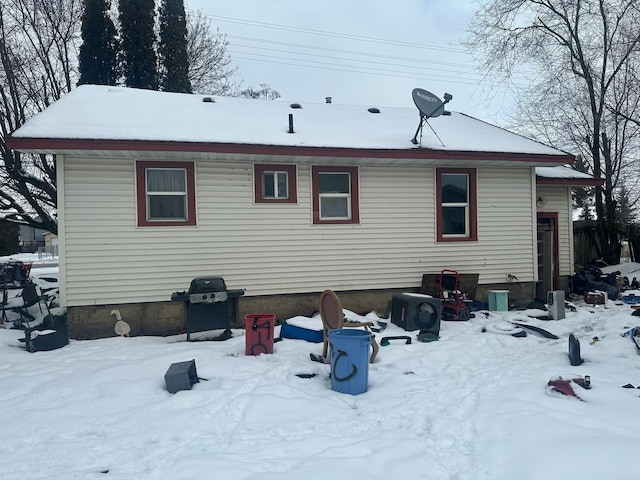 view of snow covered rear of property