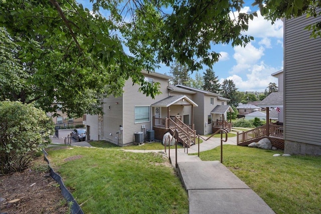 view of front of home featuring central air condition unit, a deck, and a front lawn