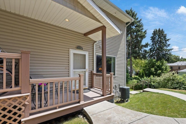 doorway to property with a lawn and central AC