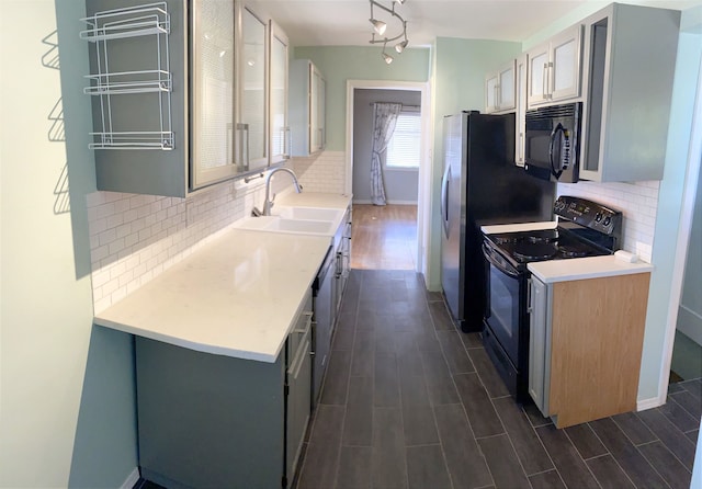 kitchen featuring sink, tasteful backsplash, gray cabinetry, and black appliances