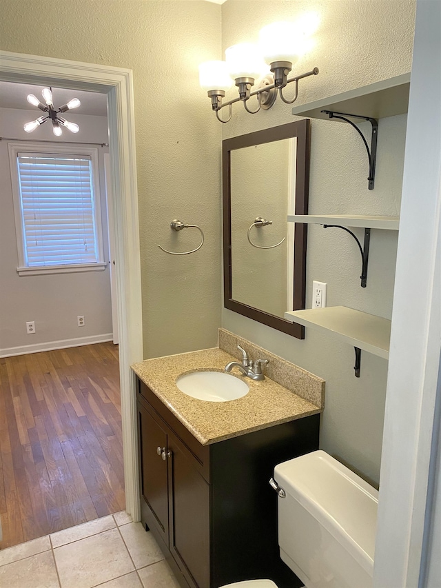 bathroom featuring vanity, a chandelier, toilet, and tile patterned floors