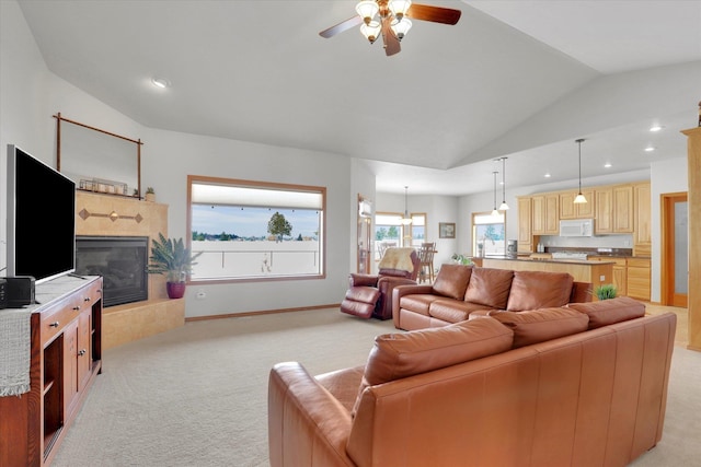 living area with light carpet, vaulted ceiling, a fireplace, and recessed lighting