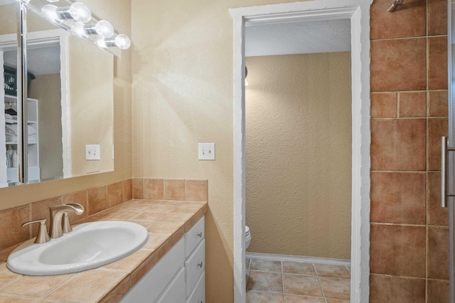 bathroom with vanity, tile patterned flooring, and toilet