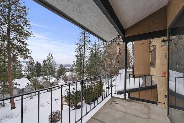 view of snow covered back of property