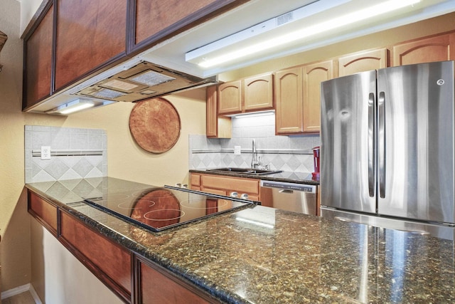 kitchen with decorative backsplash, stainless steel appliances, dark stone counters, and sink