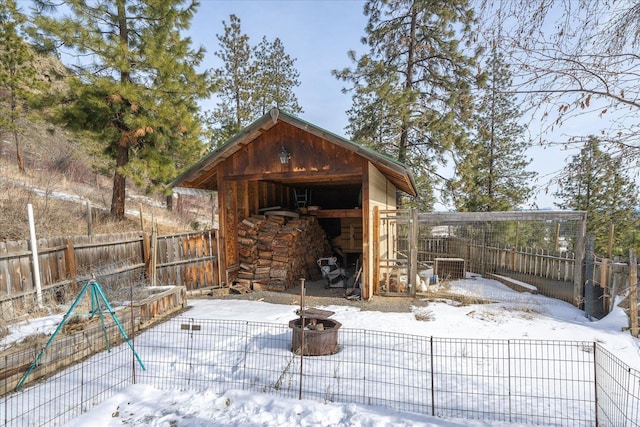 snow covered structure featuring an outdoor fire pit