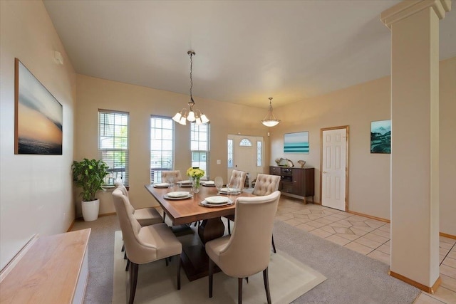 dining space featuring light tile patterned flooring and a chandelier