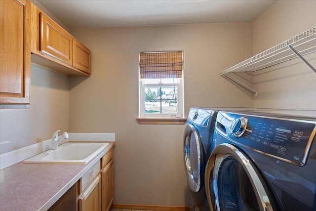 laundry room with washing machine and dryer, sink, and cabinets