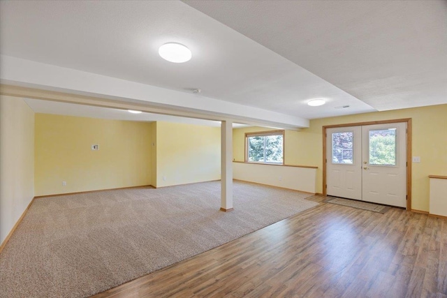 basement with hardwood / wood-style floors and french doors