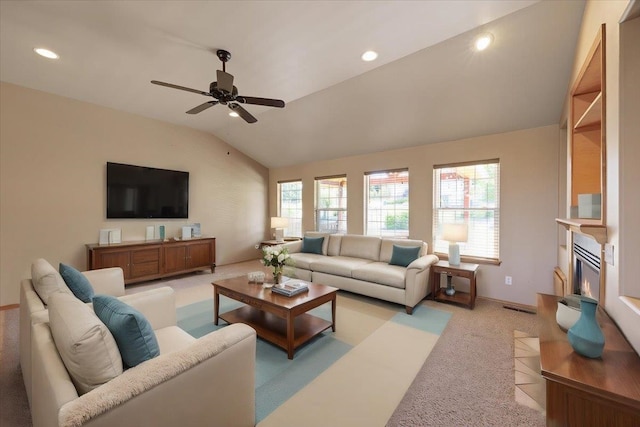 carpeted living room featuring ceiling fan, vaulted ceiling, and plenty of natural light