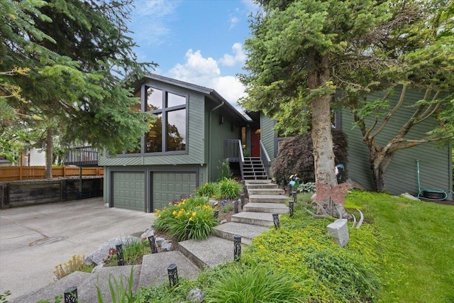 view of front of house featuring stairs, an attached garage, and driveway