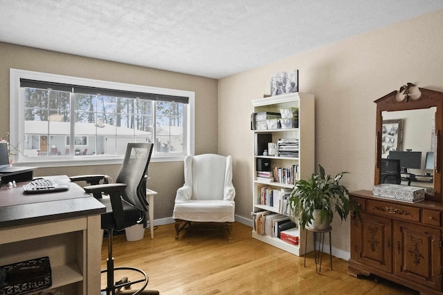 office area featuring baseboards and light wood finished floors