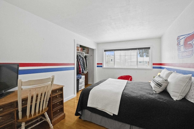 bedroom featuring a textured ceiling, a closet, and wood finished floors