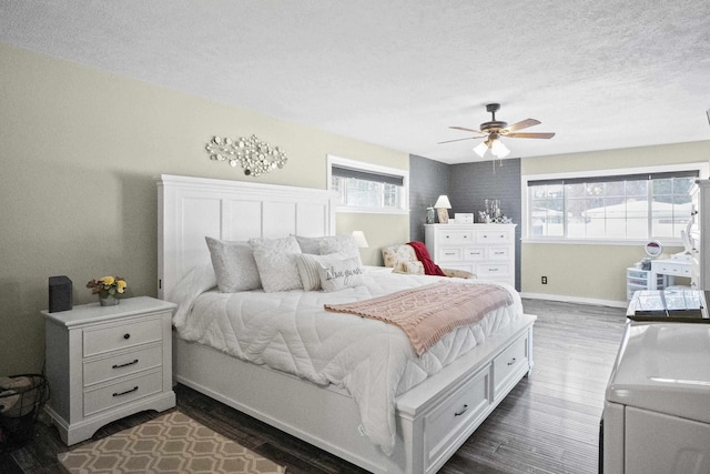 bedroom featuring dark wood finished floors, a textured ceiling, baseboards, and ceiling fan