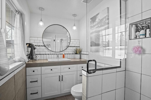 bathroom with tile patterned flooring, toilet, visible vents, vanity, and tasteful backsplash