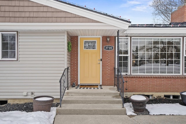 entrance to property featuring brick siding