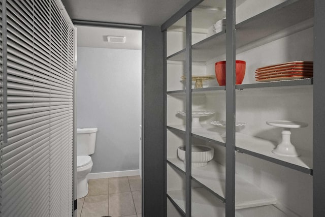 bathroom featuring toilet, tile patterned flooring, visible vents, and baseboards