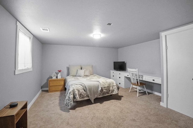 bedroom with baseboards, visible vents, a textured ceiling, and light colored carpet