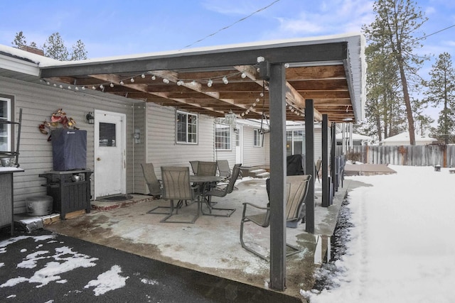 snow covered patio featuring fence