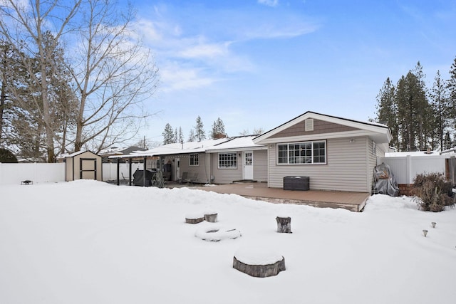 view of front facade featuring a storage shed, a garage, an outdoor structure, fence, and a wooden deck