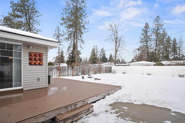 snowy yard with fence and a wooden deck