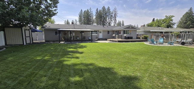 rear view of property with an outbuilding, fence, a deck, a shed, and a fire pit