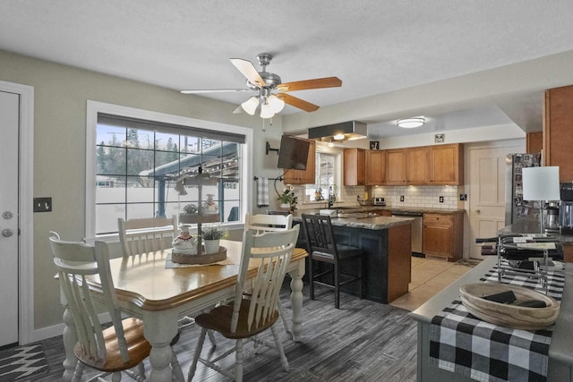 dining area with ceiling fan, light wood-style flooring, and baseboards