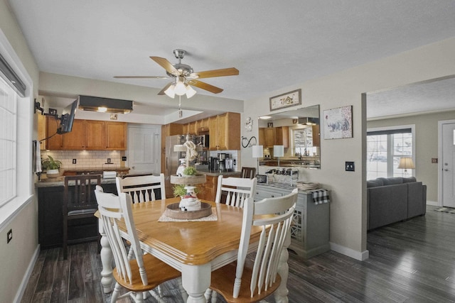 dining room featuring dark wood finished floors, a ceiling fan, and baseboards