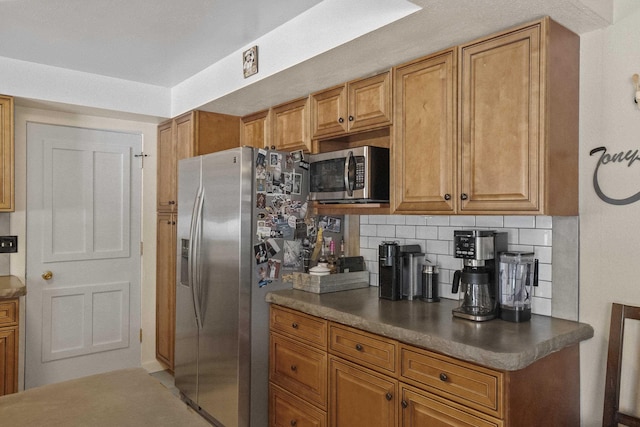 kitchen featuring appliances with stainless steel finishes, dark countertops, and tasteful backsplash