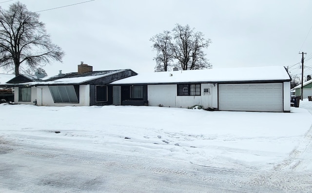 view of front facade featuring an attached garage and a chimney