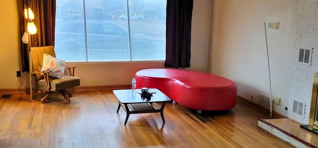 sitting room with visible vents, baseboards, and wood finished floors