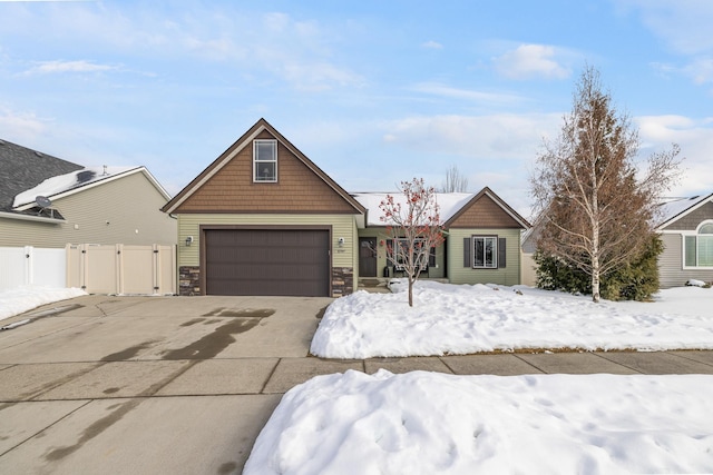 craftsman house featuring a garage, a gate, and stone siding