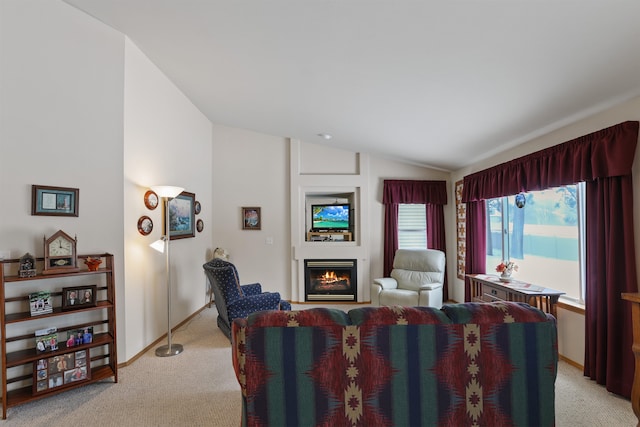 living room featuring vaulted ceiling, a lit fireplace, light carpet, and baseboards