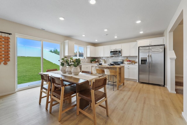 dining area featuring light wood-type flooring, visible vents, baseboards, and recessed lighting