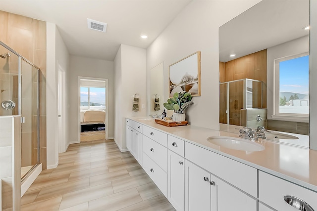 full bath with double vanity, visible vents, a stall shower, a sink, and ensuite bath