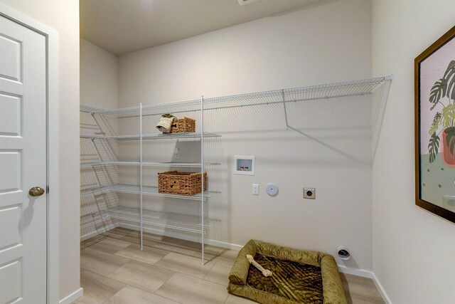 laundry area featuring gas dryer hookup, hookup for an electric dryer, laundry area, washer hookup, and baseboards