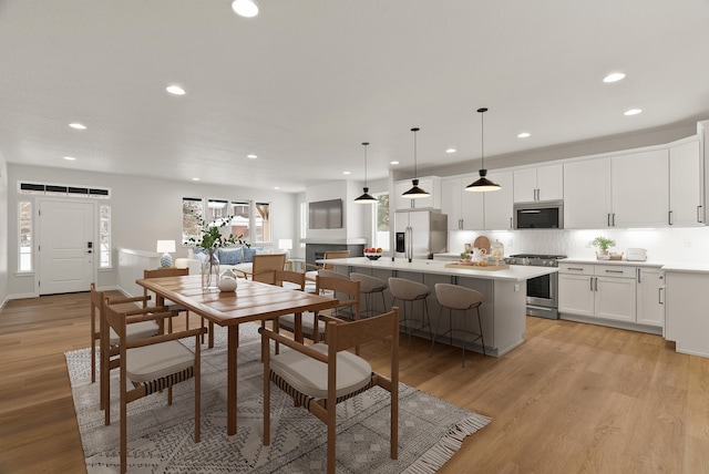 dining space featuring light wood-style flooring and recessed lighting
