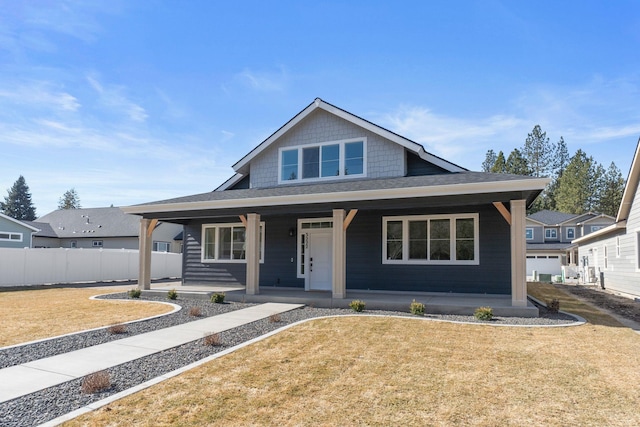 view of front of property featuring covered porch, a front lawn, and fence
