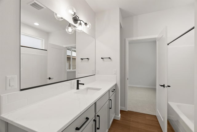 bathroom with visible vents, baseboards, wood finished floors, and vanity